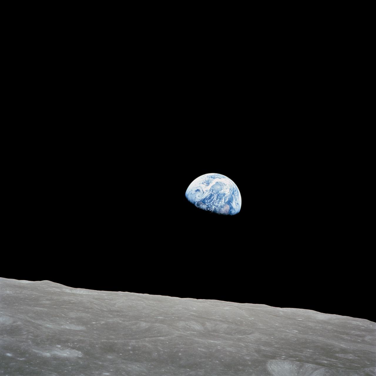 Earth above the grey lunar horizon, photographed from Apollo 8.